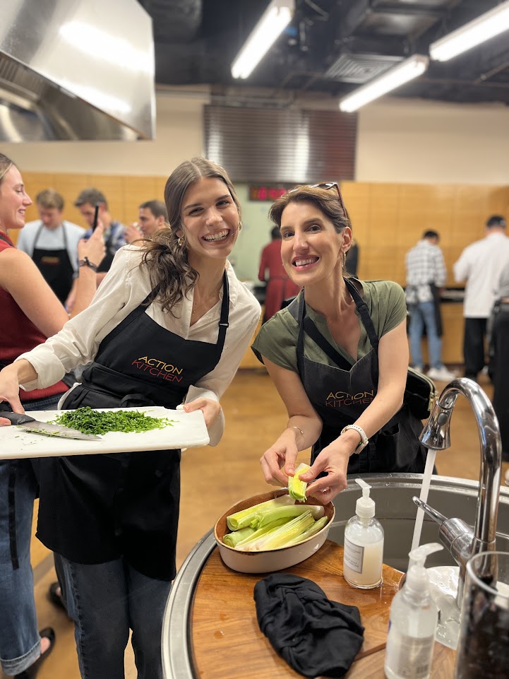 Two women smiling while cooking