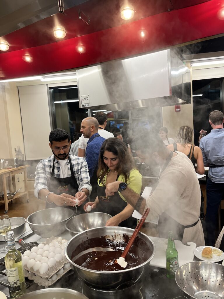 People surrounded by a boiling pot in an industrial kitchen
